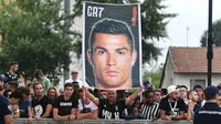 Para suporter menyambut kedatangan bintang baru Juventus, Cristiano Ronaldo, saat tiba untuk menjalani tes kesehatan di area Stadion Allianz, Turin, Senin (17/7/2018). CR 7 hijrah dari Real Madrid ke Juventus. (AFP/Miguel Medina)