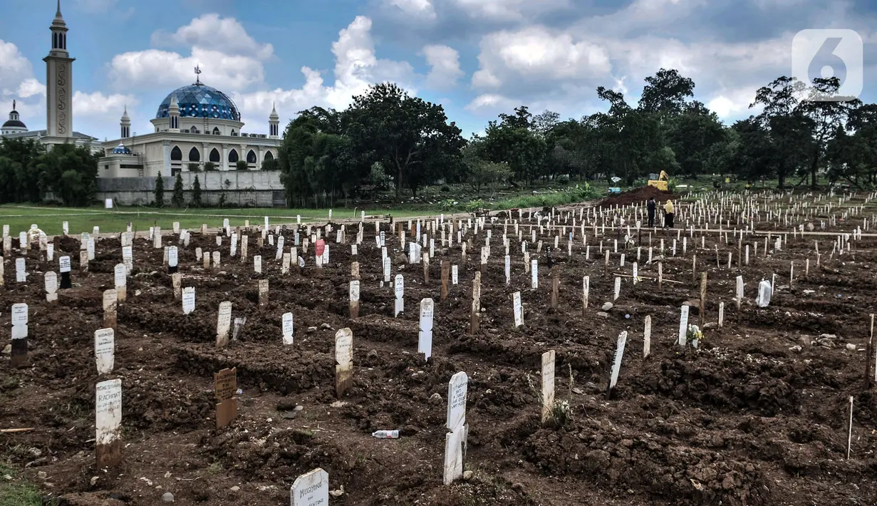 Petugas menggunakan kendaraan alat berat di sekitar kompleks pemakaman protokol Covid-19, Jakarta, Selasa (2/3/2021). TPU Bambu Apus kini tidak lagi menampung pemakaman jenazah protokol Covid-19 akibat lahan di dua blok sudah penuh dan dialihkan ke TPU Srengseng Sawah. (merdeka.com/Iqbal S Nugroho)