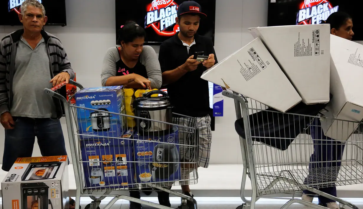Pengunjung usai membeli barang elektronik pada hari "Black Friday" di sebuah toko di Sao Paulo, Brasil, (24/11). Black Friday menjadi penanda dimulainya musim berbelanja bagi warga Brasil menjelang Natal. (REUTERS/Andrew Kelly)
