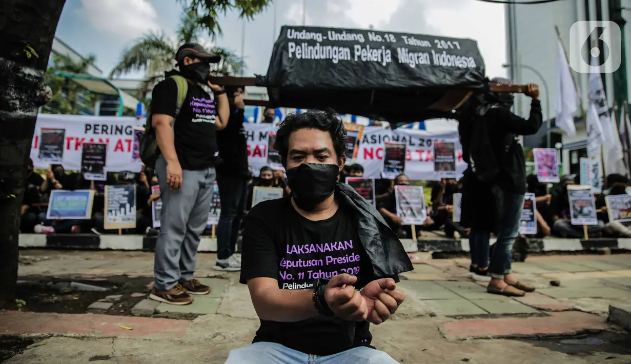 Pengunjukrasa dari Serikat Buruh Migran Indonesia membawa keranda dalam aksi di depan Kementerian Ketenagakerjaan, Jakarta, Rabu (18/12/2019). Aksi  memperingati Hari Buruh Migran Internasional itu mendesak Negara bertanggung jawab atas perlindungan hak buruh migran. (Liputan6.com/Faizal Fanani)