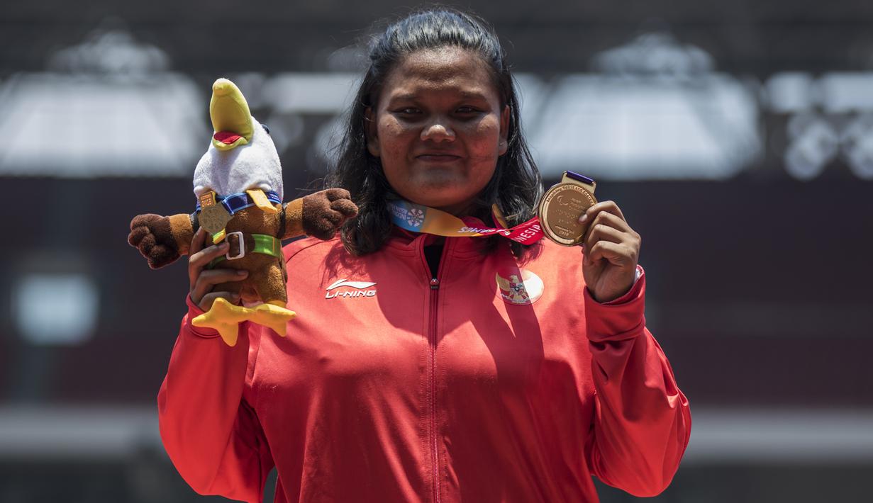 Atlet tolak peluru Indonesia, Suparniyati, tampak gembira usai meraih medali emas Asian Para Games 2018 di SUGBK, Jakarta, Senin (8/10/2018). (Bola.com/Vitalis Yogi Trisna)
