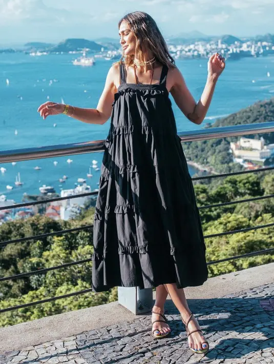 Luna Maya tampil mengenakan dress panjang hitam ruffle yang dipadukan sandal bertali. Dipadukan kalung chokernya. Credit: Havaianas