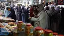 Kesulitan ekonomi membuat banyak warga Palestina di Kota Gaza harus lebih cermat dalam berbelanja kebutuhan Ramadan. Tampak dalam foto, para wanita Palestina berdiri di depan sebuah kios yang menjual manisan di pasar Zawiya, Kota Gaza, pada Rabu 18 Februari 2026. (Omar AL-QATTAA/AFP)