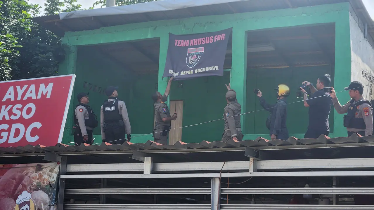 Tim gabungan Berantas Jaya Polres Metro Depok menertibkan bendera ormas yang terpasang di kawasan GDC, Depok. (Liputan6.com/Dicky Agung Prihanto)