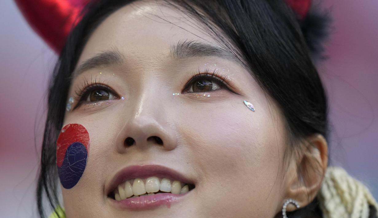 Dalam aksinya, para suporter wanita ini tampil cantik dengan melukis bendera Korea Selatan di bagian pipi. (AP Photo/Alessandra Tarantino)