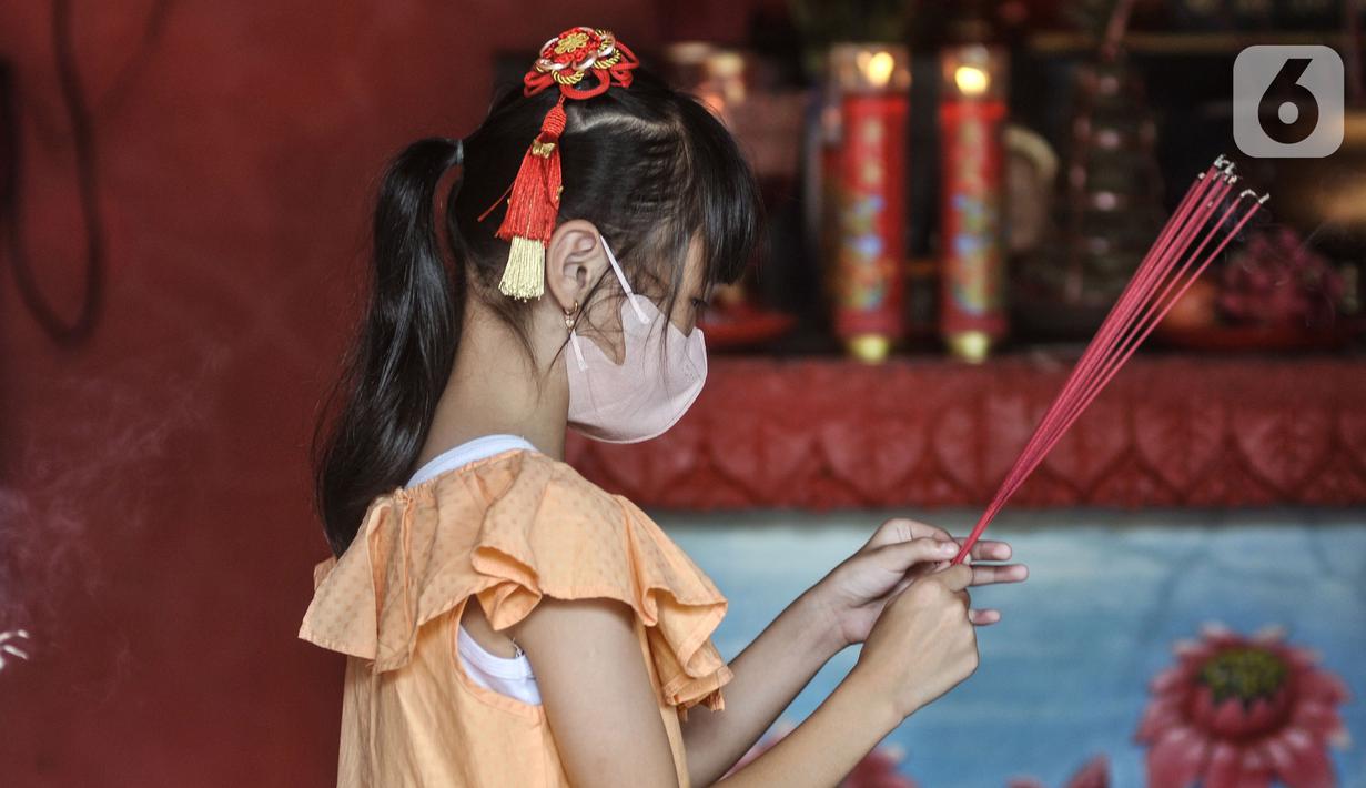 Seorang anak keturunan Tionghoa saat sembahyang Tahun Baru Imlek 2574 di Wihara Buddha Dharma & Pho Sat, Tajur Halang, Bogor, Minggu (22/1/2023). Wihara Buddha Dharma & Pho Sat atau yang juga dikenal dengan Wihara Buddha Tidur menjadi salah satu tempat ibadah warga Tionghoa dalam merayakan Tahun Baru Imlek sebagai ungkapan rasa syukur atas rejeki dan keselamatan dari tuhan serta untuk pengharapan kehidupan lebih baik di tahun Kelinci Air. (merdeka.com/Iqbal S Nugroho)