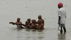 Penjual susu (kanan) menyaksikan umat Hindu melakukan ritual selama gerhana matahari di pertemuan Sungai Gangga dan Sungai Yamuna di Sangam, Prayagraj, India, Minggu (21/6/2020). Fenomena gerhana matahari pada 21 Juni 2020 terlihat dari berbagai negara di dunia. (AP Photo/Rajesh Kumar Singh)