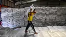 Sementara itu, stok beras di Sumatera Utara tercatat sebanyak 25 ribu ton dan di Sumatera Barat sekitar 9 ribu ton. Tampak dalam foto, seorang pekerja membawa sekarung beras di gudang Badan Urusan Logistik (Bulog) di Lambaro, Provinsi Aceh pada 29 Desember 2025. (CHAIDEER MAHYUDDIN/AFP)