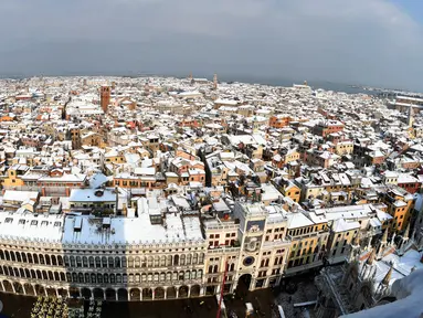 Pemandangan udara salju menutupi atap rumah dan bangunan saat hujan salju lebat terjadi di Venesia, Italia, Rabu (28/2). Cuaca ekstrem dan salju melanda negeri tersebut dan menciptakan temperatur di bawah nol selama beberapa hari. (Andrea PATTARO/AFP)