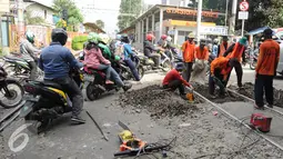 Antrean pengendara sepeda motor saat menyebrangi rel kereta api di kawasan Stasiun Karet, Jakarta, Rabu (28/12). Perawatan dan pengecekan rutin rel kereta api itu guna menjamin keselamatan perjalanan kereta api. (Liputan6.com/Gempur M. Surya)