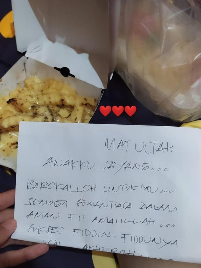 Seorang yang memberi hadiah makanan di hari ulang tahun anaknya.