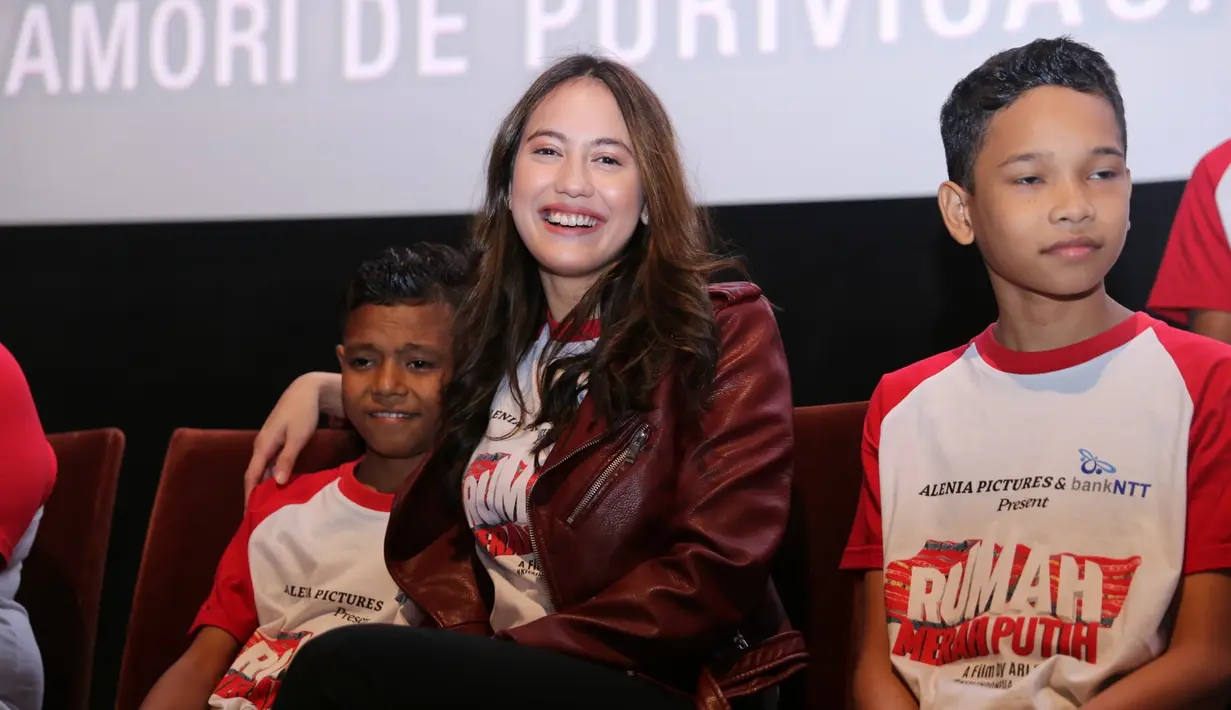 Pevita Pearce terduduk santai bersama dua anak cast film Rumah Merah Putih. Pevita merangkul cast anak yang terlihat malu-malu. Senyum Pevita terlihat begitu manis saat screening film Rumah Merah Putih (KapanLagi.com/Adrian Utama Putra)