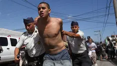 Petugas polisi membawa narapidana yang ditangkap dari penjara Juvenile Gaviotas di Guatemala City, Guatemala (3/7). Kerusuhan di penjara tersebut terjadi usai dua narapidana ditemukan tewas tergantung. (AP Photo / Moises Castillo)