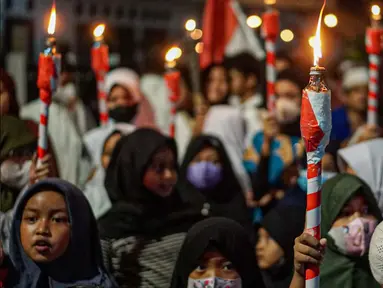 Warga mengikuti pawai obor menyambut Ramadan di kawasan Matraman Dalam, Jakarta, Minggu (27/3/2022). Pawai obor tersebut juga digelar untuk meningkatkan silaturahmi dan ukhuwah sesama umat Muslim serta menyemarakkan syiar Islam di Ibu Kota. (Liputan6.com/Faizal Fanani)