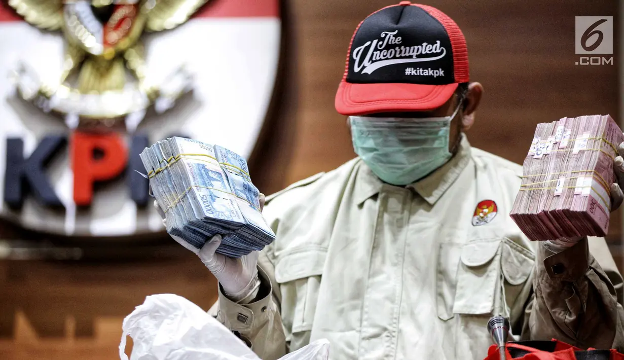 Penyidik menunjukkan barang bukti OTT Bupati Lampung Selatan Zainudin Hasan berupa uang senilai Rp 600 juta. di Gedung KPK, Jumat (27/7). Zainudin ditetapkan sebagai tersangka dugaan suap proyek infrastruktur. (Liputan6.com/Faizal Fanani)