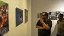 Menteri Koperasi dan UKM, AAGN Puspayoga melihat karya saat pembukaan Anugerah Pewarta Foto Indonesia (APFI) 2017 di Jakarta, Jumat (21/4). (Liputan6.com/Faizal Fanani)