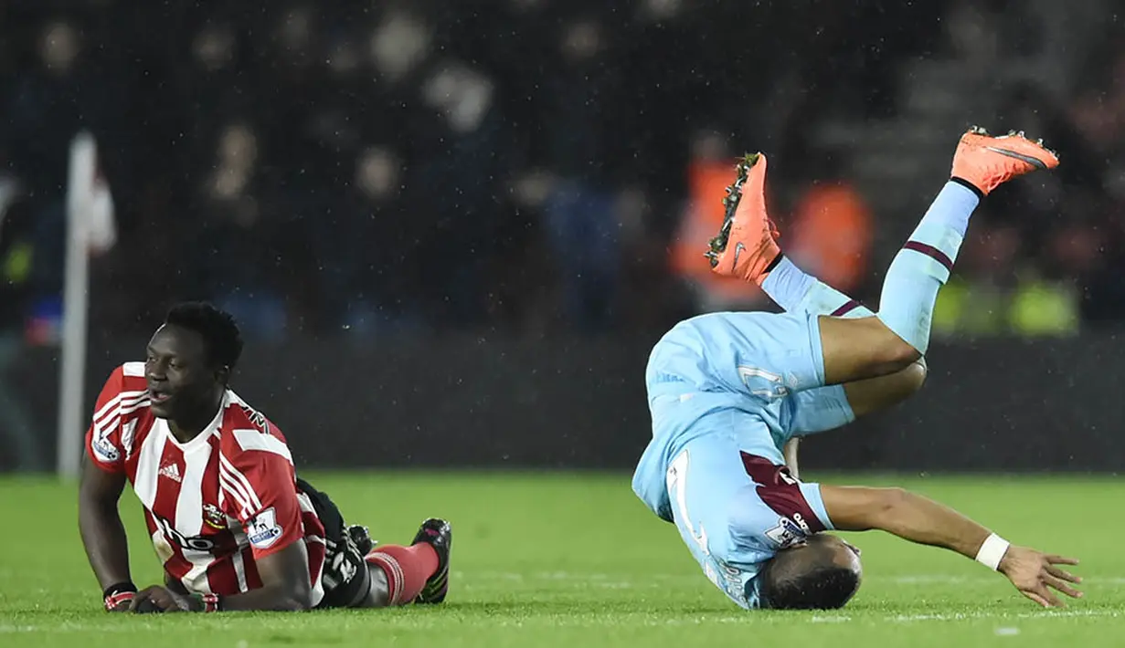 Pemain Southampton, Victor Wenyama dan pemain West Ham, Dimitri Payet, terjatuh saat berlaga di Stadion St Mary, Inggris, Sabtu (6/2/2016). Southampton berhasil menang 1-0 atas West Ham. (Reuters/Hannah McKay)