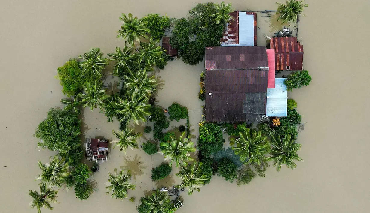 Foto udara menunjukkan sebuah rumah yang terendam banjir di Kangar, negara bagian Perlis, Malaysia utara, pada Jumat 28 November 2025. Hujan deras tanpa henti sejak awal pekan membuat aliran sungai di sejumlah wilayah Malaysia Utara meluap, hingga akhirnya merendam kawasan permukiman. (Mohd RASFAN/AFP)