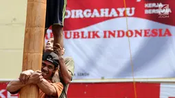 Peserta panjat pinang bekerja sama memanjat pohon saat mengikuti lomba di kawasan Jalan Jaksa, Jakarta, Kamis (17/8). Lomba diadakan untuk memeriahkan HUT RI ke-72. (Liputan6.com/Helmi Fithriansyah)