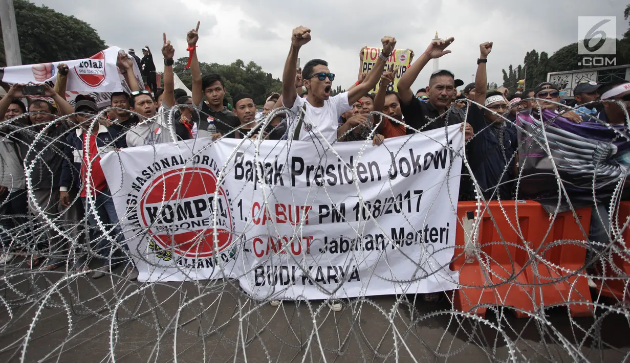Demonstran driver online berorasi sambil membentangkan spanduk saat unjuk rasa  di depan Istana Negara, Jakarta, Rabu (14/2). Massa meneriakkan suaranya meminta Menhub Budi Karya, untuk menghapus Permenhub 108 tahun 2017. (Liputan6.com/Arya Manggala)