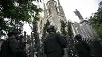 Personel kepolisian berjaga di depan Gereja Katedral, Jakarta, Kamis (1/4/2021). Sebanyak 150 personel gabungan TNI, Polri dan Satpol PP melakukan pengamanan jelang rangkaian perayaan Hari Paskah di gereja tersebut. (Liputan6.com/Faizal Fanani)