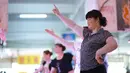 Pedagang berjoget ketika pengunjung mulai sepi di sebuah pasar di Nanning, Provinsi Guangxi, China, Senin (5/6). Di tengah kesibukan berjualan para pedagang ini meluangkan waktu dengan menari dan berolahraga bersama. (Reuters/Stringer)