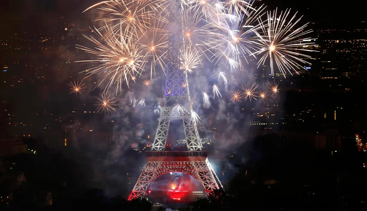 Kembang api menerangi langit di Menara Eiffel saat perayaan tradisional Hari Bastille di Paris, Prancis (14/7). Peringatan ini menandai penyerbuan penjara Bastille pada 14 Juli 1789, yang memicu revolusi Prancis. (REUTERS/Pascal Rossignol)