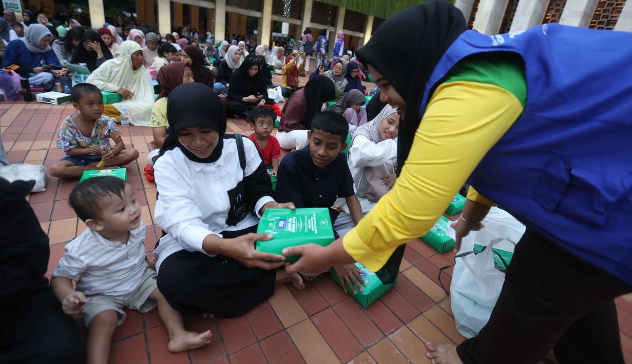 Menurut panitia pelaksana, sekitar 4.000 hingga 5.000 paket nasi kotak disediakan setiap harinya. Tampak dalam foto, petugas membagikan makanan untuk berbuka puasa pada hari pertama Ramadan 1447 Hijriah di Masjid Istiqlal, Jakarta, Selasa (19/2/2026). (Kapanlagi.com/Budy Santoso)