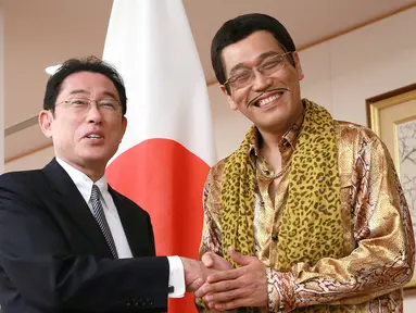 Komedian Jepang Pikotaro berjabat tangan dengan Menteri Luar Negeri Jepang Fumio Kishida di Kementerian, Tokyo, Rabu (12/7). Pikotaro diundang untuk mendampingi Menlu ke pertemuan PBB di markas besar, New York. (AP/ Eugene Hoshiko)