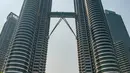 Sejumlah orang memotret di depan Menara Kembar Petronas, Kuala Lumpur, Malaysia, 18 Maret 2016. Kombinasi antara gedung pencakar langit dan situs bersejarah serta perpaduan harmonis beragam budaya semakin memperkaya pesona khas dari Kuala Lumpur. (Xinhua/Chong Voon Chung)