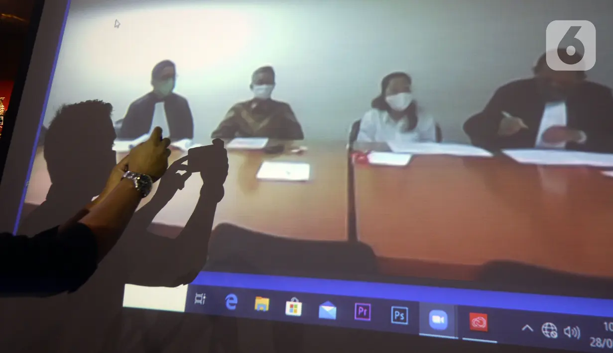 Mantan Komisioner KPU Wahyu Setiawan (kedua kiri) mendengarkan Jaksa Penutut Umum membacakan dakwaan saat sidang secara daring di Gedung KPK, Jakarta, Kamis (28/5/2020). Wahyu menjalani sidang dakwaan terkait kasus dugaan menerima suap pengurusan PAW anggota DPR dari PDIP. (merdeka.com/Dwi Narwoko)