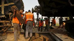 Pekerja mengevakuasi gerbong yang rusak parah usai kecelakaan yang melibatkan dua kereta penumpang di Palwal, India, Selasa (8/12). Menurut media setempat, kejadian itu menewaskan satu orang dan puluhan lainnya luka parah. (REUTERS/Anindito Mukherjee)