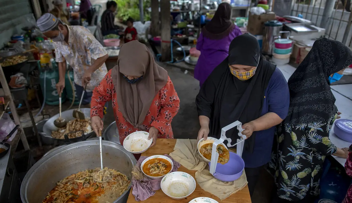 Sukarelawan memindahkan makanan ke dalam kotak di Masjid Bang Aw, Bangkok, Thailand, Kamis (30/4/2020). Setiap hari selama Ramadan, sukarelawan membagikan makanan kepada 150 keluarga sekitar Masjid Bang Aw yang tidak bisa beribadah bersama karena pandemi COVID-19. (AP Photo/Gemunu Amarasinghe)