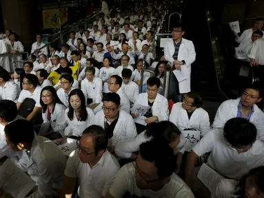Ratusan dokter mendengarkan orasi saat aksi protes di dalam sebuah rumah sakit di Hong Kong, Rabu (21/10). Ratusan dokter umum tersebut menuntut kenaikan gaji sejalan dengan kenaikan upah pegawai negeri di kota itu. (REUTERS/Bobby Yip)
