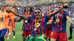 Pencetak dua gol Barcelona, Raphinha bergaya menggunakan kacamata saat melakukan selebrasi kemenangan timnya setelah menjuarai Piala Super Spanyol 2026 di King Abdullah Stadium, Jeddah, Arab Saudi, Minggu (11/01/2026) waktu setempat. (AFP/Fadel Senna)