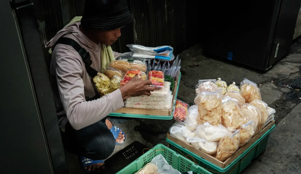 Upaya ini akan difokuskan pada peningkatan aktivitas ekonomi di triwulan IV, yang secara historis menjadi periode penggerak konsumsi dan investasi. Tampak dalam foto, seorang pedagang kaki lima mengatur makanan yang dipajang dalam keranjang di kios pinggir jalan miliknya di Jakarta pada Sabtu 8 November 2025. (YASUYOSHI CHIBA/AFP)