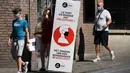 Sejumlah orang berjalan melewati spanduk informasi yang mengingatkan masyarakat untuk mengenakan masker di Brussel, Belgia (5/8/2020). Kota Brussel memperluas aturan wajib pakai masker di wilayahnya hingga termasuk di jalan-jalan yang ramai dan zona pejalan kaki. (Xinhua/Zheng Huansong)