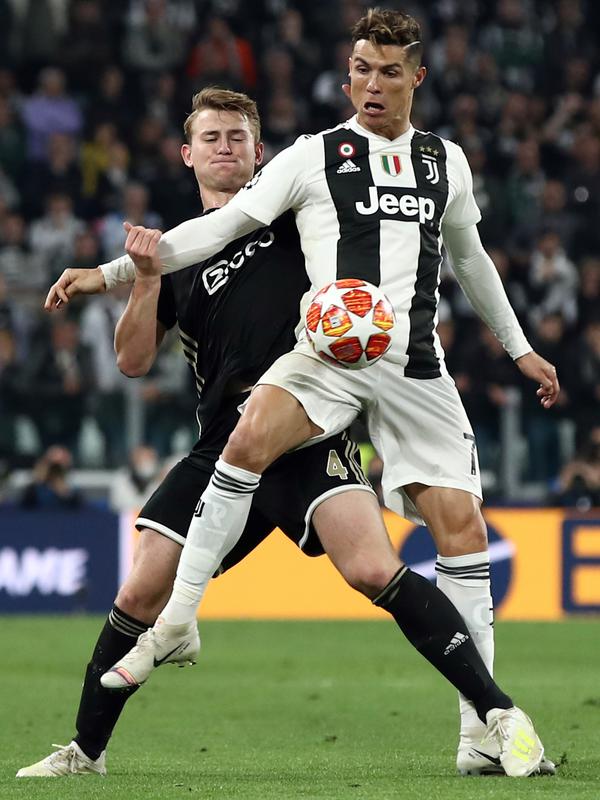 Bek Ajax Amsterdam, Matthijs de Ligt  berusaha merebut bola dari penyerang Juventus, Cristiano Ronaldo selama pertandingan leg kedua perempat final Liga Champions  di stadion Juventus di Turin (16/3/2019). Juventus mengontrak de Ligt selama selama lima tahun. (AFP Photo/Isabella Bonotto)