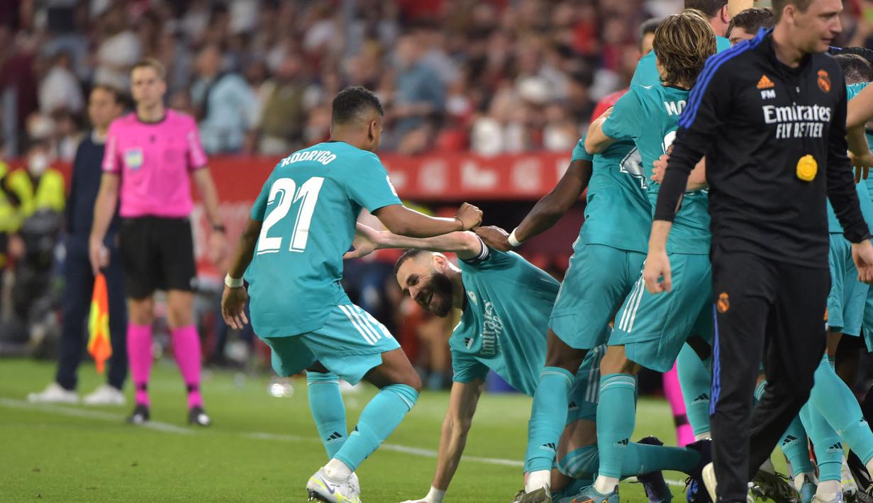 Sontak seluruh pemain dan juga ofisial tim langsung menghampirinya untuk merayakan epic comeback yang diraih Real Madrid saat bertamu ke kandang Sevilla. (AFP/Cristina Quicler)