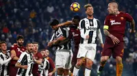 Duel udara antara pemain Juventus dan AS Roma dalam laga pekan ke-17 Serie A 2016-2017 di Juventus Stadium, Sabtu (17/12/2016) waktu setempat. (AFP/Marco Bertorello)