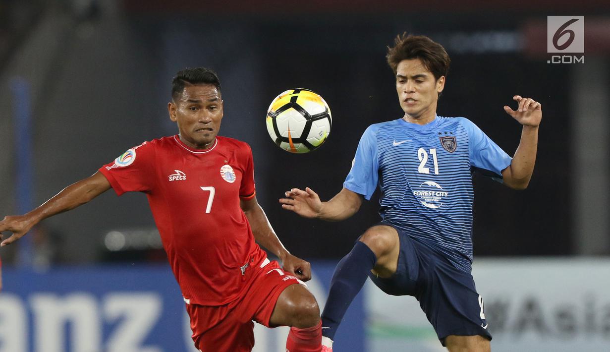 Gelandang Persija, Ramdani Lestaluhu (kiri) berebut bola dengan pemain Johor Darul Takzim pada lanjutan penyisihan Grup H Piala Asia 2018 di Stadion GBK, Jakarta, Selasa (10/4). Babak pertama Persija unggul 3-0. (Liputan6.com/Helmi Fithriansyah)