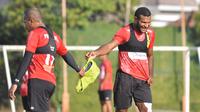 Striker Persipura Jayapura, Marinus Wanewar, memberikan vest latihan kepada seniornya Ian Louis Kabes ketika menjalani latihan di Kota Batu. (Bola.com/Iwan Setiawan)