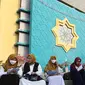 Umat Islam membaca Al-Quran sambil menunggu waktu berbuka puasa di halaman Masjid Raya Jakarta Islamic Center, Jakarta Utara, Senin (18/4/2022). Acara ngabuburit sambil khataman Al-Quran ini merupakan rangkaian acara menyambut 17 Ramadhan atau malam Nuzulul Quran. (Liputan6.com/Herman Zakharia)