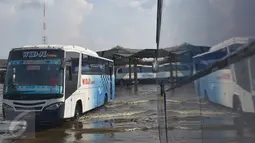 Bus melintasi banjir akibat air laut pasang atau rob yang menggenangi Terminal Terboyo di Semarang, Minggu (15/5/2016). Banjir rob tersebut mengakibatkan penumpang memilih turun di luar terminal, sehingga aktivitas di dalam terminal lumpuh. (Foto: Gholib)