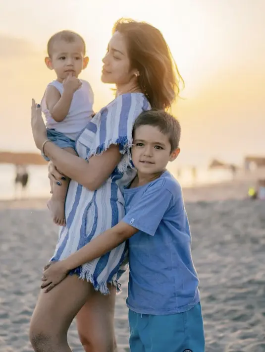 Jessica Iskandar mengenakan jumpsuit motif garis-garis bersama kedua anaknya di pantai. @inijedar