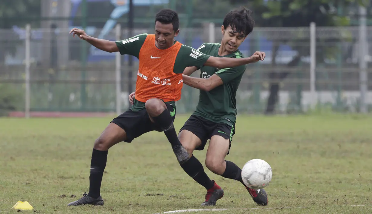 Pemain Timnas Indonesia U-22, Syafril Lestaluhu, berebut bola dengan Lutfhi Kamal saat latihan di Lapangan ABC, Jakarta, Senin (14/1). Latihan ini merupakan persiapan jelang Piala AFF U-22. (Bola.com/Vitalis Yogi Trisna)