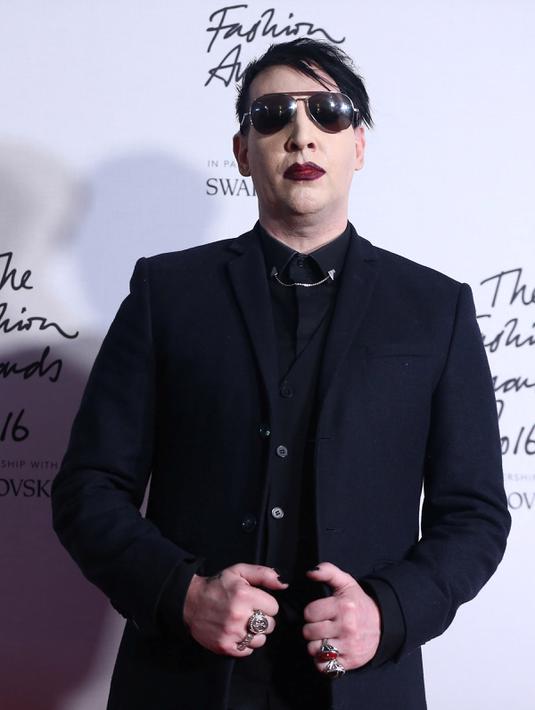 Penyanyi, Marilyn Manson berpose saat menghidiri di Fashion Awards 2016 di London, Inggris (5/12). Mantan pacar Evan Rachel Wood tersebut tampil Fashionable dengan Jas dan kacamata hitam dengan gigi dan cincin ditangannya. (REUTERS/Neil Balai)
