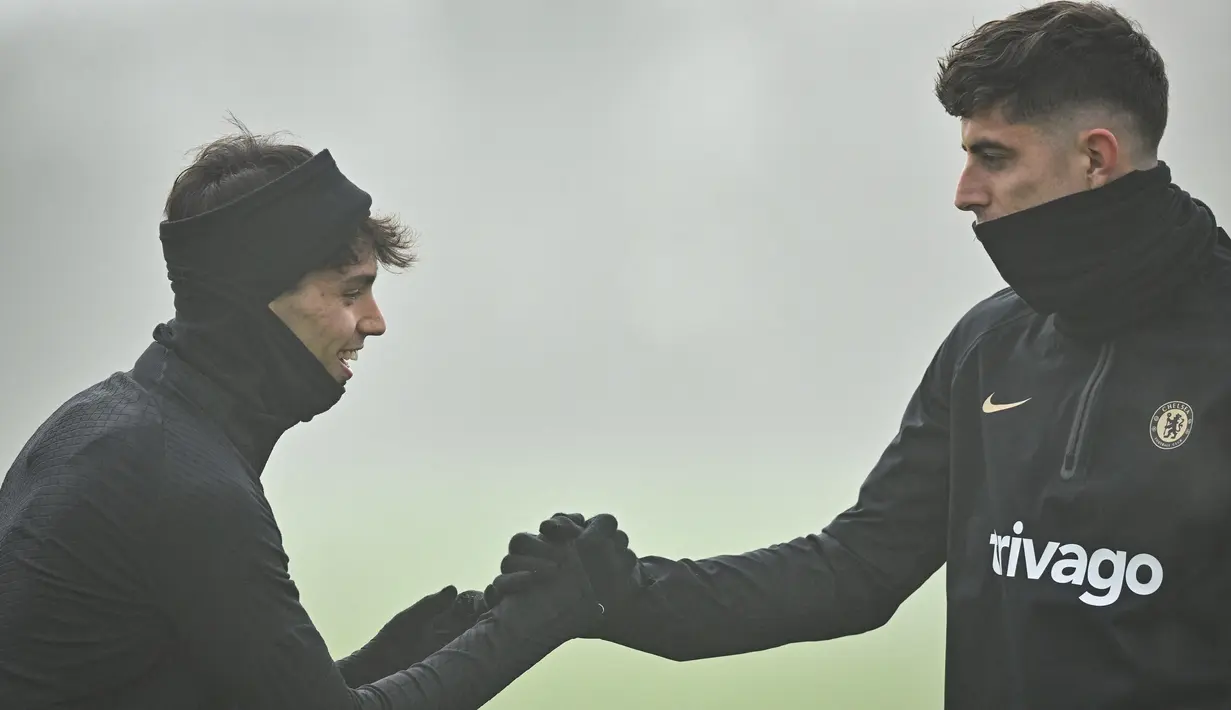 <p>Penyerang Chelsea, Joao Felix (Kiri) dan gelandang Kai Havertz (Kanan) berbicara bersama saat menghadiri sesi latihan tim di fasilitas latihan Chelsea di Cobham di Stoke D'Abernon, London pada 14 Februari 2023. The Blues lolos sebagai juara Grup E di atas AC Milan, Red Bull Salzburg dan Dinamo Zagreb. (AFP/Glyn Kirk)</p>