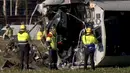 Petugas menyelidiki sebuah kereta yang tergelincir sesaat setelah menabrak crane (derek) di Dalfsen, Belanda, Selasa (23/2). Kecelakaan itu menewaskan sang masinis dan melukai empat pengemudi mobil yang berada di dekat lokasi kejadian. (REUTERS/NOS)