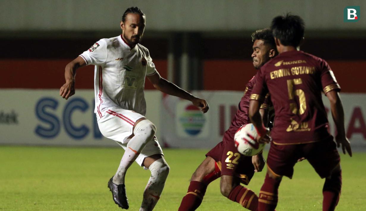 Gelandang Persija Jakarta, Rohit Chand (kiri) melepaskan tendangan yang coba diblok striker PSM Makassar, Yakob Sayuri (tengah) dalam laga leg pertama semifinal Piala Menpora 2021 di Stadion Maguwoharjo, Sleman, Kamis (15/4/2021). Kedua tim bermain imbang 0-0. (Bola.com/Ikhwan Yanuar)
